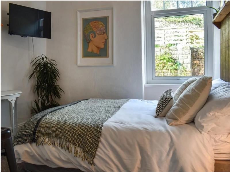 Photo of a double guest bedroom, with warm blankets, plush cushions and framed art